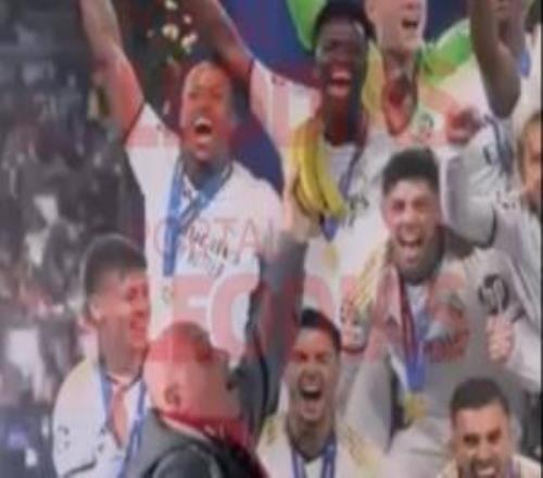 一本菲卡球迷參觀伯納烏時(shí)，手拿香蕉放在維尼修斯照片前合影