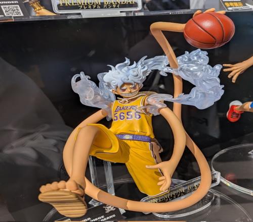 “ONE PIECE × NBA MASTER STARS PIECE 路飛（LOS ANGELES LAKERS）”，尺寸高約 30 公分，采用覺醒橡膠果實(shí)后的五檔-太陽神尼卡型態(tài)的路飛，身披洛杉磯湖人隊(duì)?wèi)?zhàn)袍。