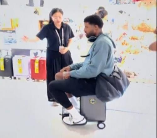 很丝滑！中国行期间保罗乔治骑了骑电动行李箱