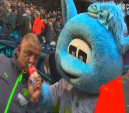 又来了上场手持阿森纳水瓶出圈的球迷赛前与曼城吉祥物合影